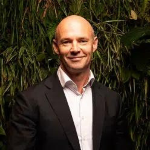 Man in a suit standing against a green foliage backdrop, representing Australian Ethical ASX AEF.