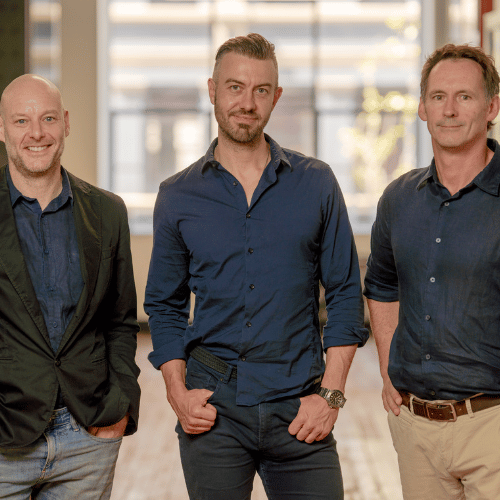 Three men in business casual attire standing in a modern office, representing Limepay.